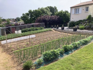 Le potager au printemps et la volière en fond.